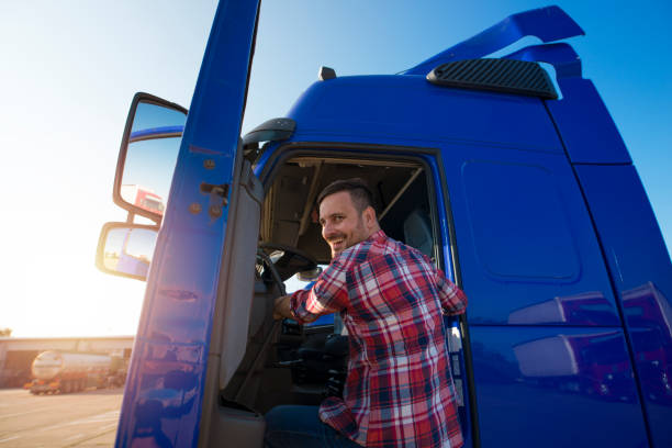 выстрел мотивированных улыбаясь среднего возраста водитель грузовика ввода его полу грузовик длинный автомобиль. счастливый дальнобойщи� - truck semi truck blue truck driver стоковые фото и изображения