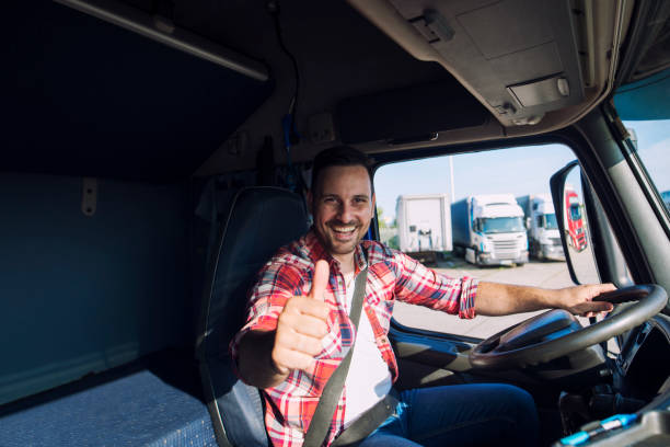 portrait of professional motivated truck driver holding thumbs up in truck cabin. transportation service. - semi truck cargo container mode of transport horizontal imagens e fotografias de stock