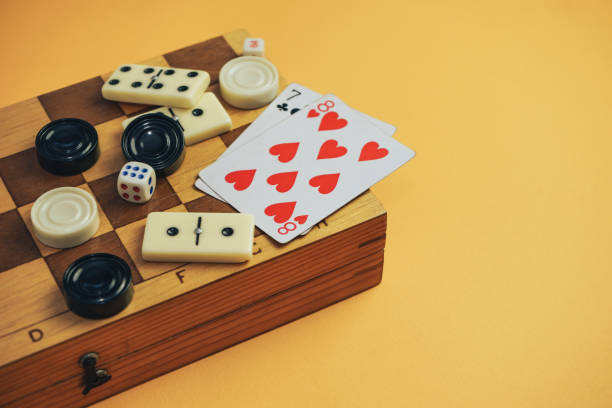 istock Various board games chess board, playing cards, dominoes on a orange background. 1178890521