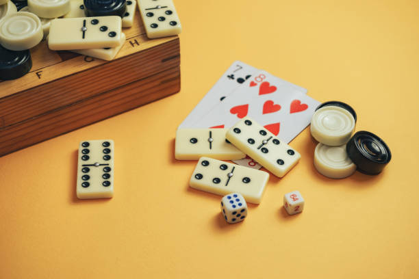 istock Various board games chess board, playing cards, dominoes on a orange background. 1178891066