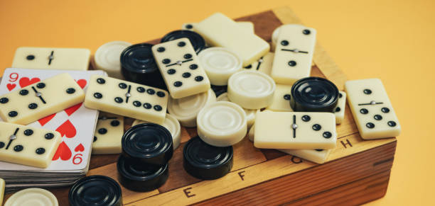 istock Various board games chess board, playing cards, dominoes on a orange background. 1178891117