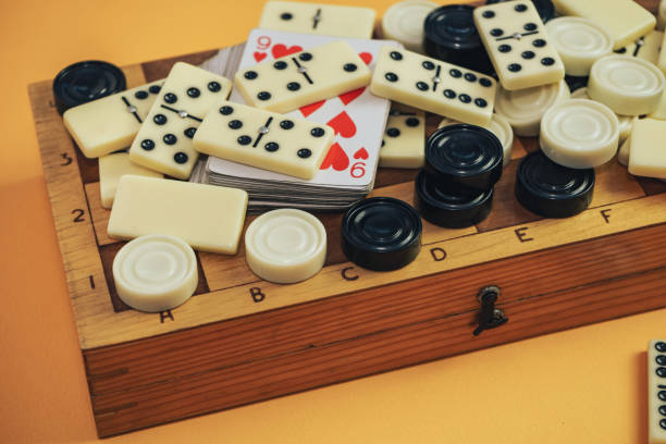 istock Various board games chess board, playing cards, dominoes on a orange background. 1178891134