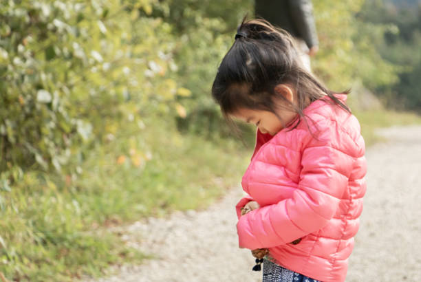 menina eurasian-mestiço francês e chinês-aprendendo a fechar seu casaco sozinho-aprendendo a vida-tornando-se independente - child autumn nature human face - fotografias e filmes do acervo