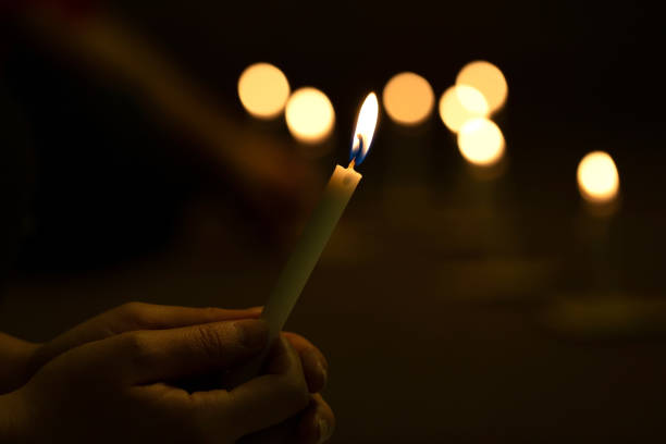 feche acima das mãos que iluminam a vigília da vela na escuridão. conceito de luz da esperança., adoração, oração. foco macio - orthodox orthodox church christianity church - fotografias e filmes do acervo