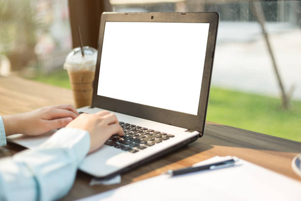istock Close-up of business female working with laptop with blank black screen make a note document and smartphone in coffee shop like the background. 1178896071
