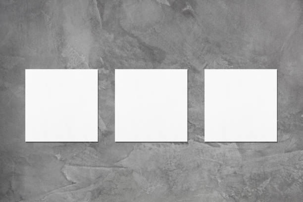 istock Three empty white square business card mockups on dark grey concrete background 1178896305
