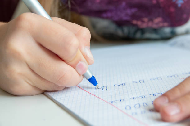 istock Kid holding pen and writing in notebook. Close up 1178896504