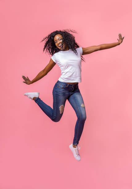 istock Stunning young girl jumping over pink background 1178902875