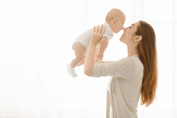 istock Mother touching noses with her baby while lifting him up 1178903415