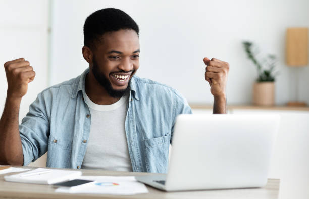 istock Euphoric black man celebrating business success with raised arms 1178904966