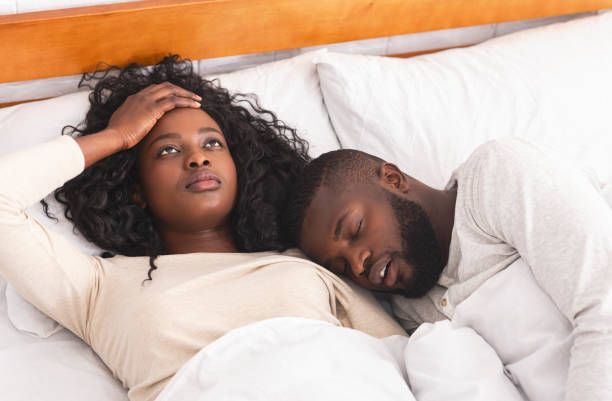 mujer joven frustrada molestapor por el marido roncando fuerte en la cama - couple love snoring sleeping fotografías e imágenes de stock