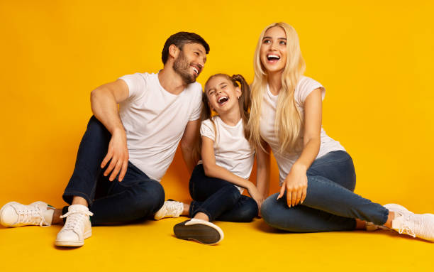 istock Parents And Daughter Laughing Sitting On Floor In Studio 1178907023