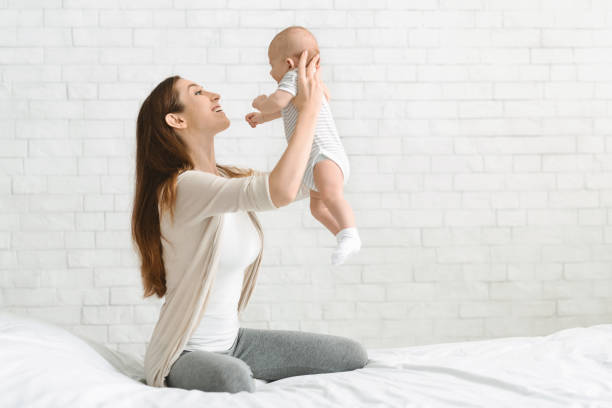 istock Young mother playing with her infant son, lifting him up 1178907842