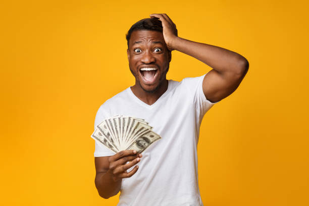 istock Excited Afro Guy Holding Money Shouting Touching Head, Yellow Background 1178908780