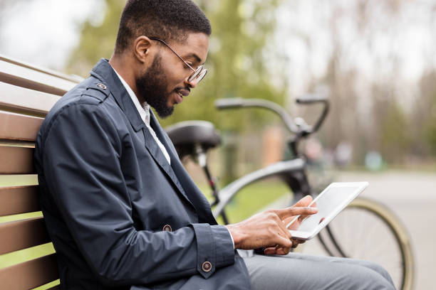 istock Afro businessman having break and using tablet in park 1178909433