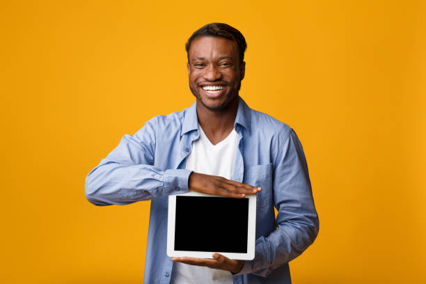 istock Smiling African American Man Showing Tablet Screen In Studio, Mockup 1178909834