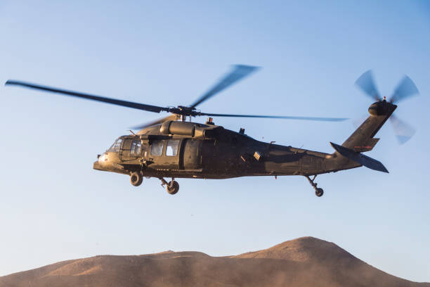 istock Military helicopter flying over hills 1178910115