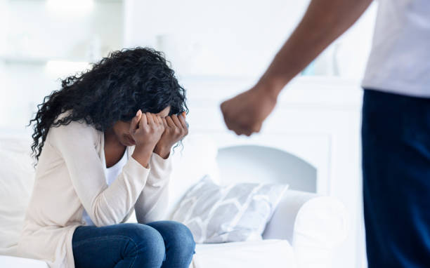 mujer escondiendo su rostro del puño del marido, sufriendo de abuso - violence black men women fotografías e imágenes de stock