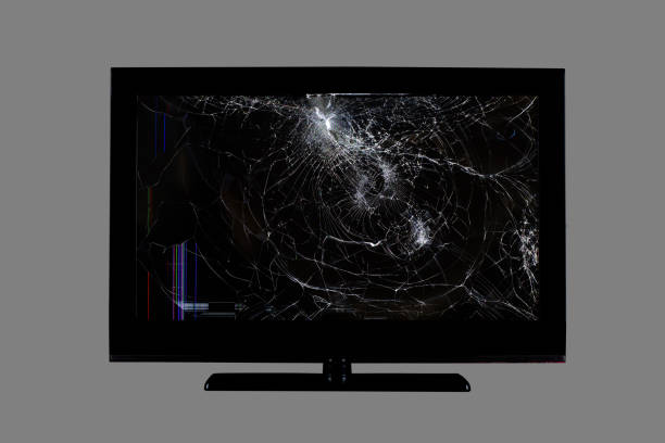 colored stripes and cracks on a black broken screen of a liquid crystal display, computer monitor or full hd television isolated on a grey background