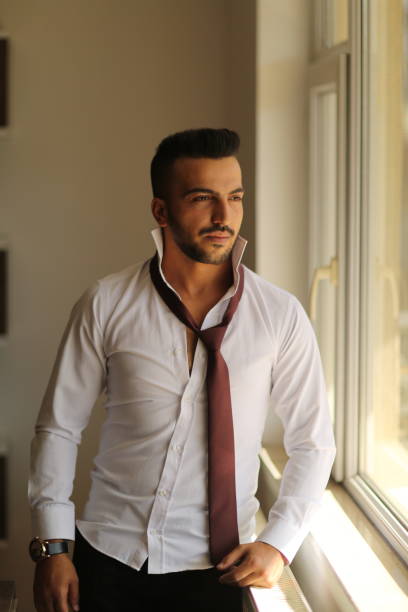 istock Handsome man looking thoughtfully while standing at the window and looking out 1178914739
