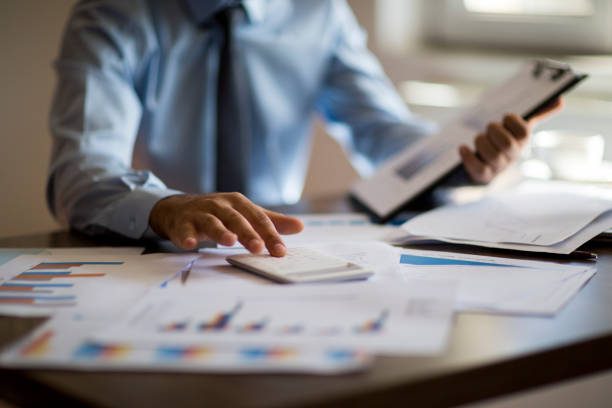 business accounting konzept, geschäftsmann mit taschenrechner mit computer-laptop, budget und leihpapier im büro. - gewinn stock-fotos und bilder