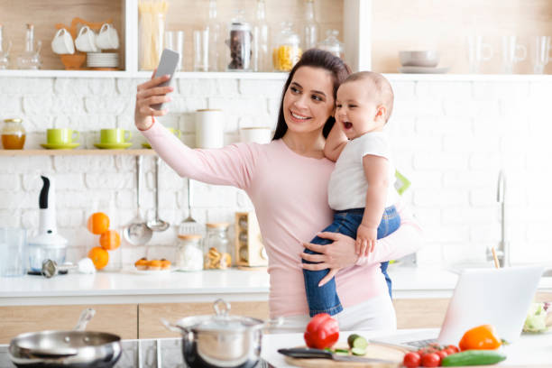 istock Millennial mother taking selfie on cellphone, smiling at camera 1178917434