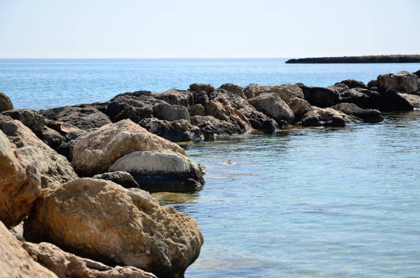 istock Volcanic rock dam at sea on summer day 1178917740