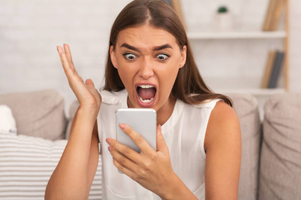 istock Furious Girl Screaming On Phone Sitting On Couch Indoor 1178918325