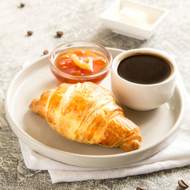 istock breakfast with croissants. fresh crispy croissants and coffee on a light background, top view. 1178919096