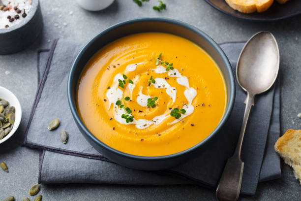 istock Pumpkin, carrot cream soup in a bowl. Grey background. 1178919135