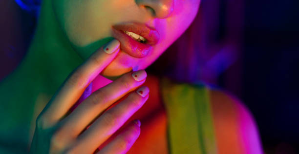 istock Model holding hand near lips in studio with neon lights 1178919528