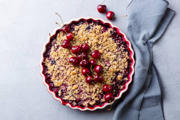 istock Cherry, red berry crumble in baking dish. Grey stone background. Top view. 1178919685