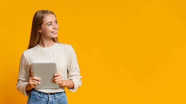 istock Beautiful girl holding digital tablet and looking at copy space 1178919912