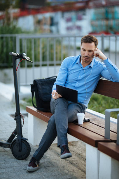 istock Businessman using digital tablet in the city park after scooter riding 1178921212