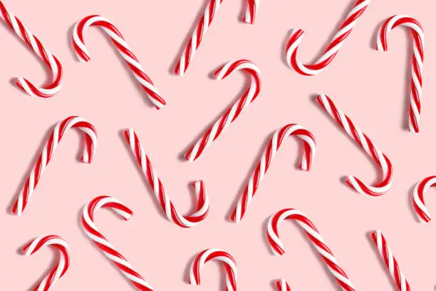 Photo of Candy cane for party design on pink background.