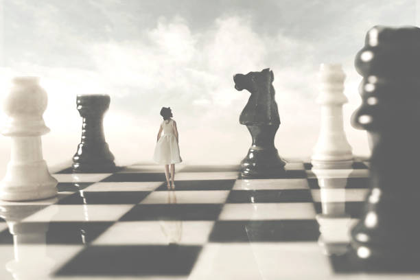 femme qui est alliée avec les chessborads blancs regarde avec méfiance à son rival noir; concept de stratégie - brain case photos et images de collection