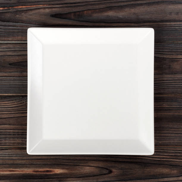 istock White square Plate on wooden table background. Perspective view 1178922320
