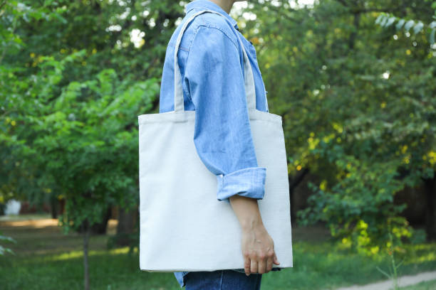 istock Young woman holding tote bag against greenery, copy space 1178923996