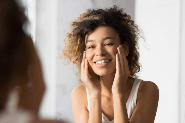 istock Black Girl Touching Face Looking In Mirror In Bathroom 1178925141