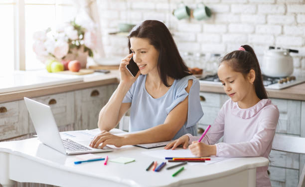 istock Young woman working at home and spending time with daughter 1178925166