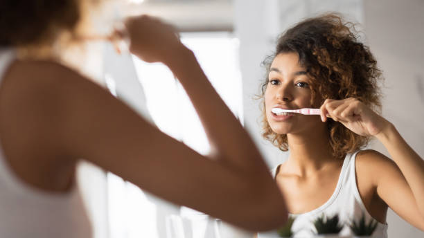 ragazza afroamericana che lava i denti con spazzolino da denti in bagno, panorama - toothbrush brushing teeth brushing dental hygiene foto e immagini stock