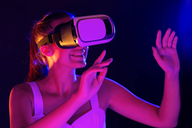 istock Young woman experiencing with VR glasses, gesturing in neon lights 1178925291
