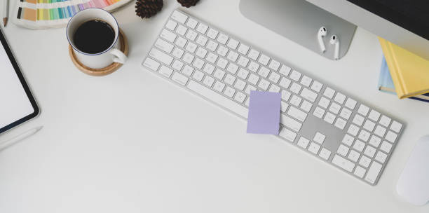 istock Top view of modern workplace with keyboard computer and office supplies on white table background 1178925374
