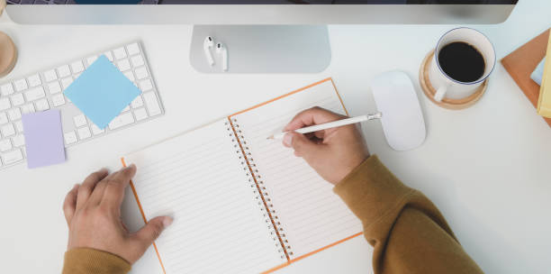 istock Overhead shot of young male writing his idea on blank notebook in his comfortable workspace 1178925528