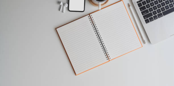 istock Overhead shot of comfortable workplace with open blank notebook on white desk background 1178925532