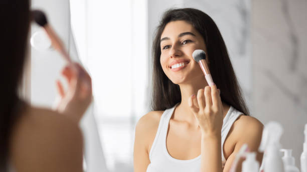 istock Girl Applying Face Powder Using Makeup Brush Standing In Bathroom 1178926645