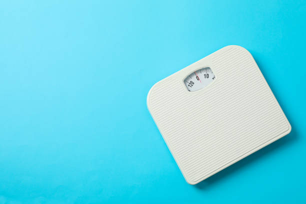 istock White weigh scales on blue background, top view 1178927741