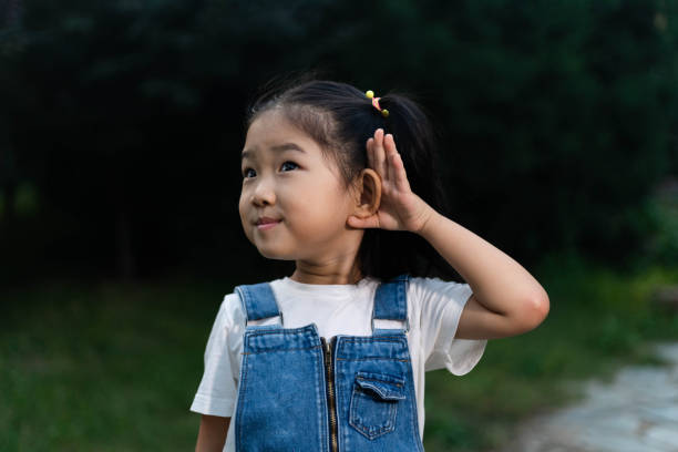 かわいい女の子リスニング - chinese ethnicity audio ストックフォトと画像