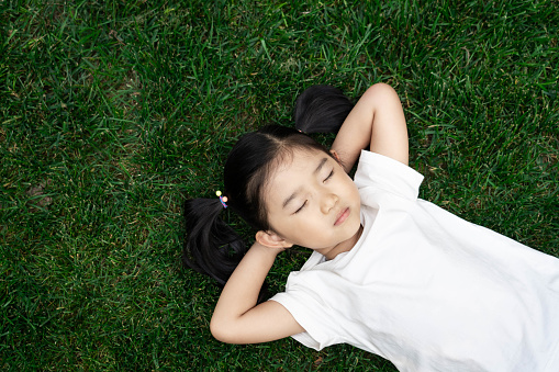 Cute girl lying down on the lawn