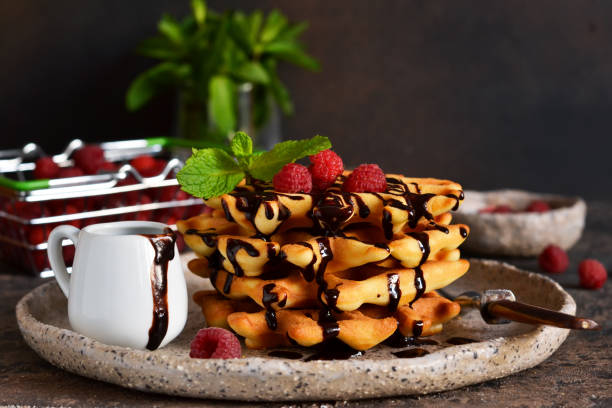 istock Homemade waffles with chocolate sauce and berries on the kitchen table. 1178929277
